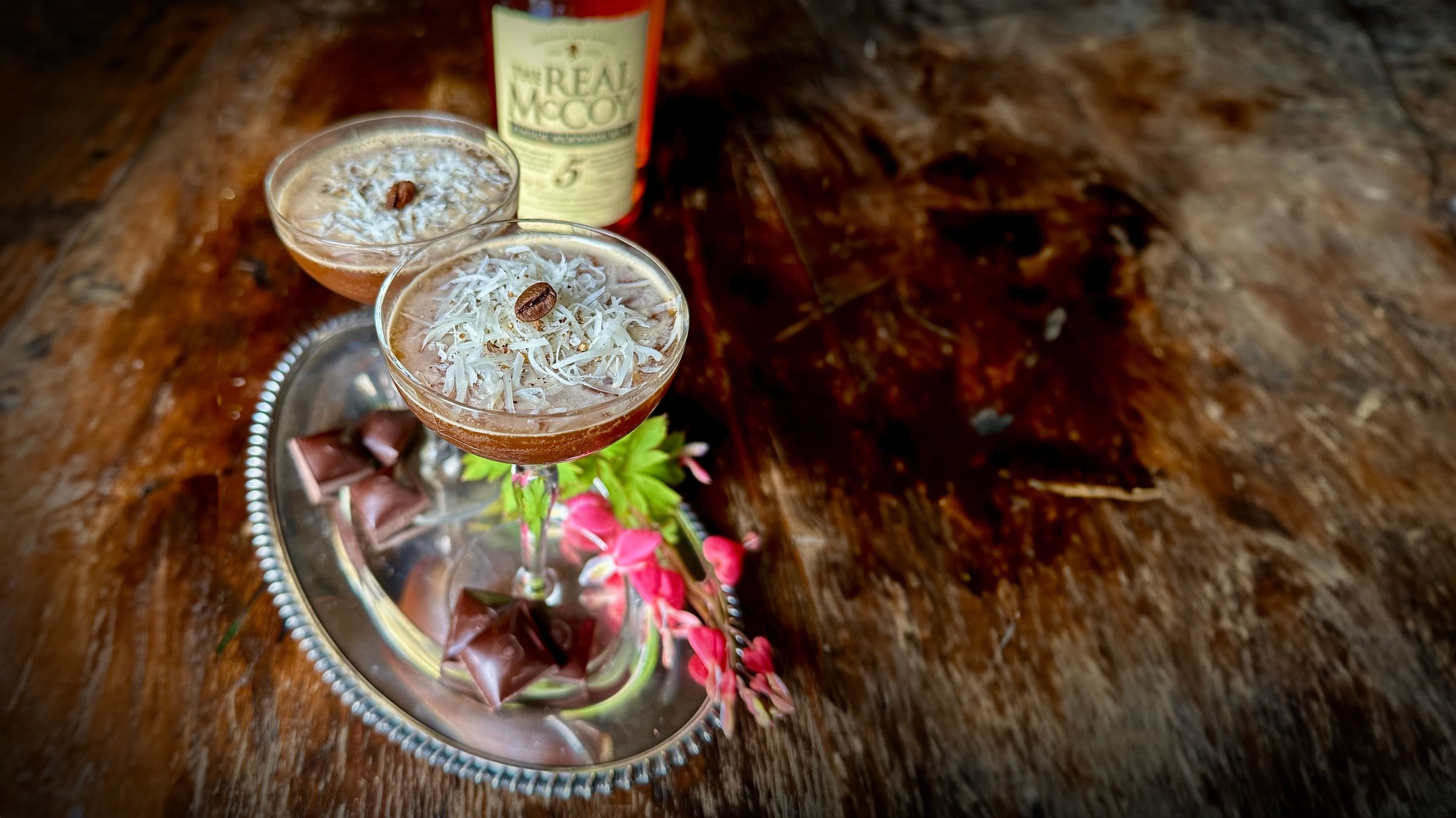 Espresso Martini with grated Cacio e Pepe on top and a bottle of 5 year aged Real McCoy Rum in the background.