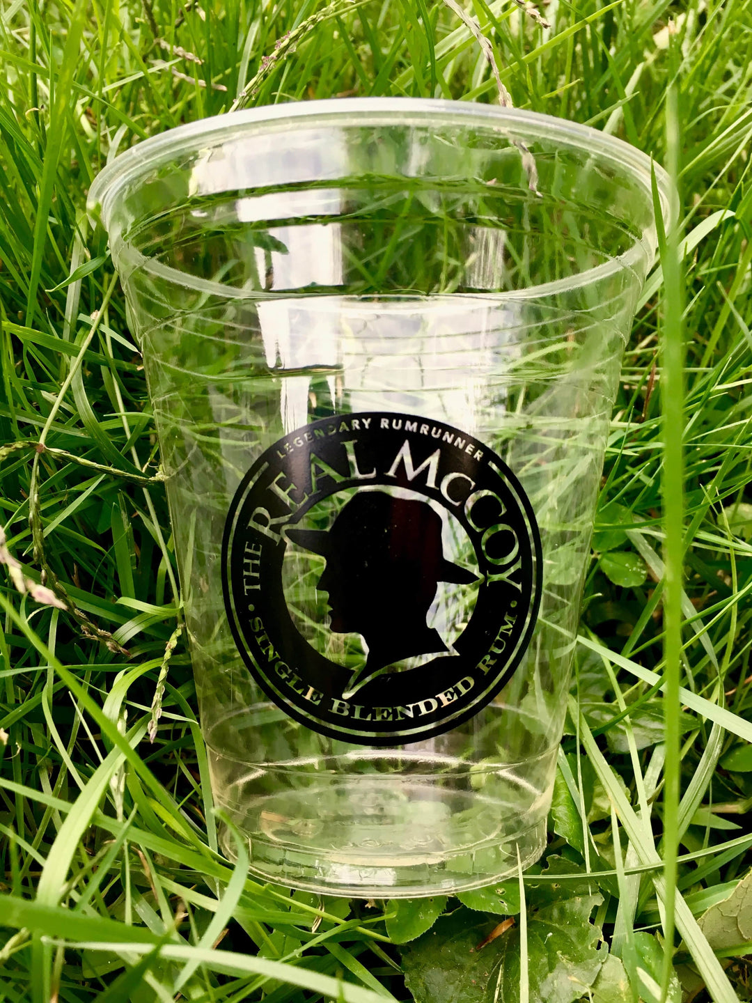 Biodegradable, Compostable Real McCoy Branded cup sitting in the grass