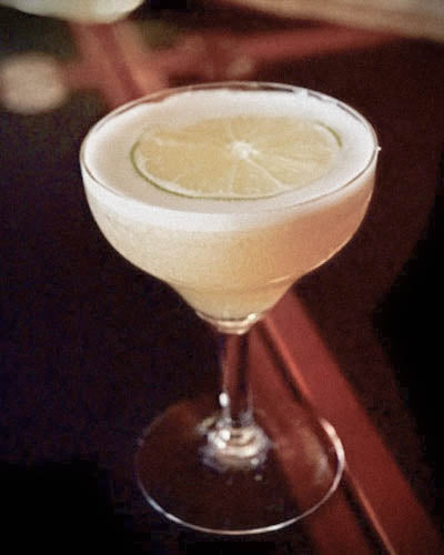 Photo of a daiquiri with a lime wheel floating on top