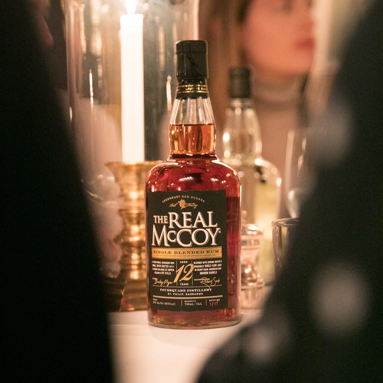 The Real McCoy 12 Year aged premium rum on a table with candles and fancy glassware at the Polo Bar. The best rum for eggnog.